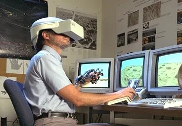 Image montrant une personne équipée d'un casque de réalité virtuelle et d'un gant éléctronique.